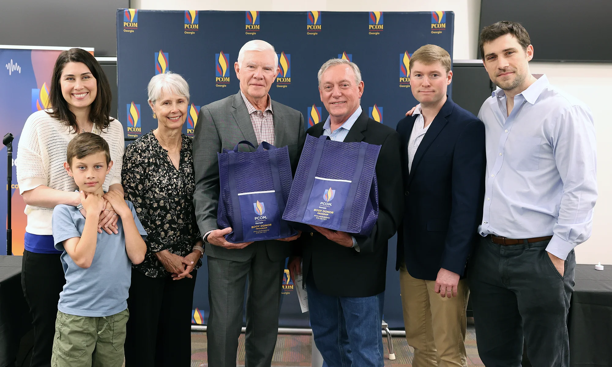 A family smiles for a group photo after a PCOM Georgia Body Donor Memorial service event