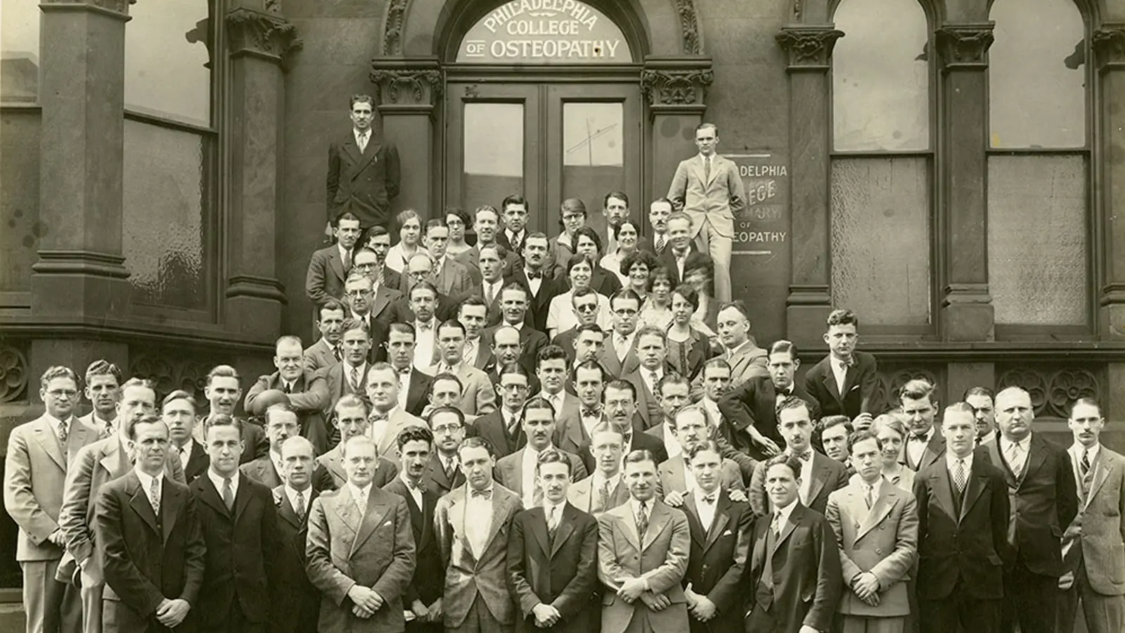 The PCOM Class of 1927 pose in front of a Philadelphia college building