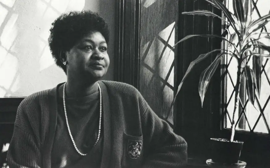 Black and white photo of first-generation female medical student, Violet A. Walker Henighan, DO '87, sitting next to a window