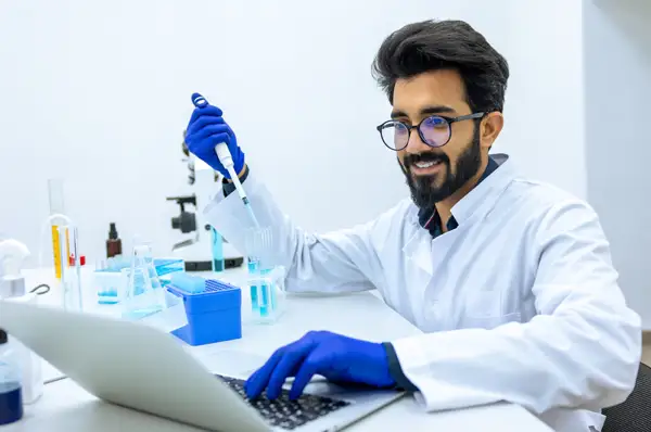 Pharmacy student sits at desk and enters data into lap top computer