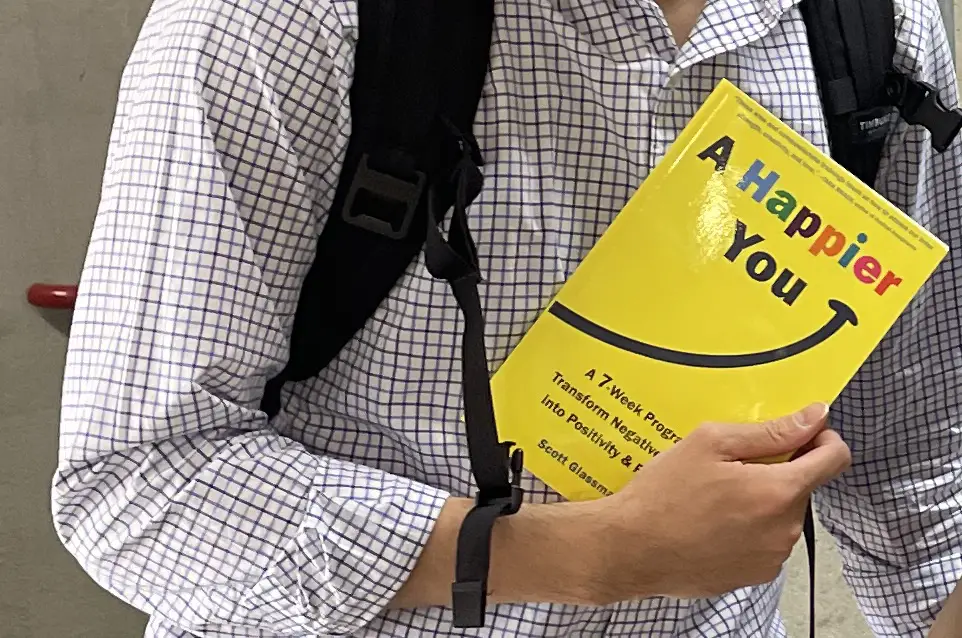 A man holds a copy of Dr. Scott Glassman's book, "A Happier You."