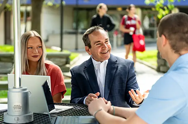 Dr. Scott Glassman speaks with two students about positive psychology.