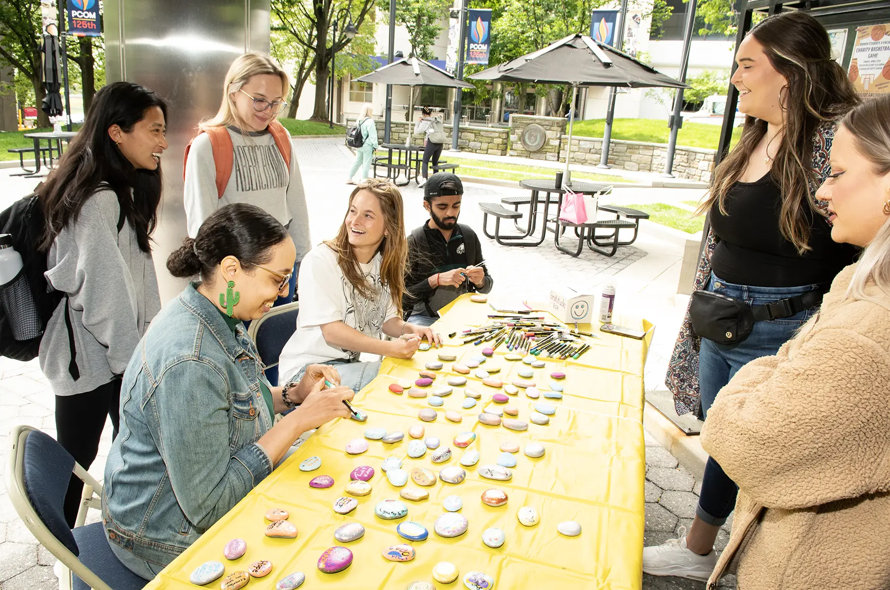 Positive psychology students and others paint rocks.