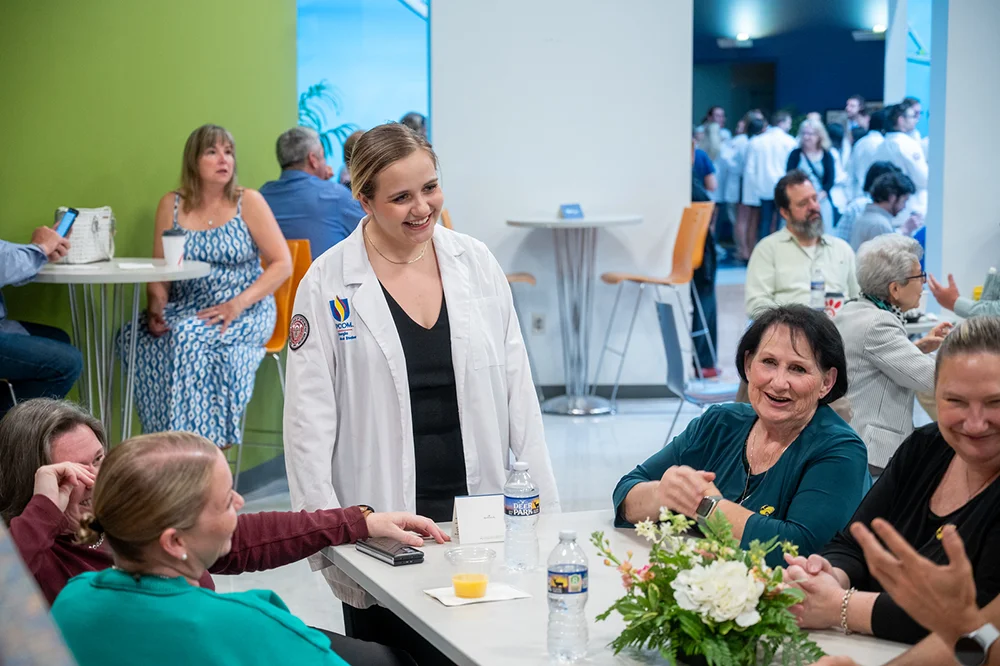 A PCOM Georgia student visits with attendees