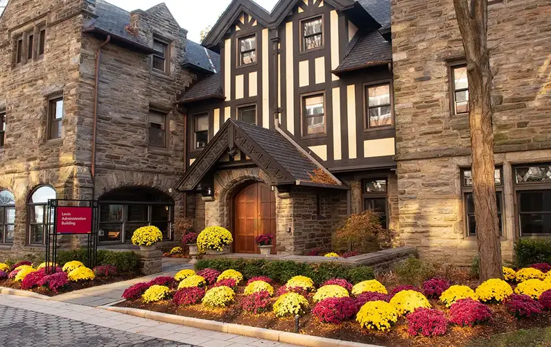 Tudor-Revival-style admin building with fall foliage