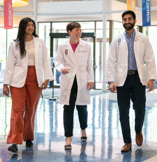 PCOM Georgia medical students and faculty walk and talk in a hallway