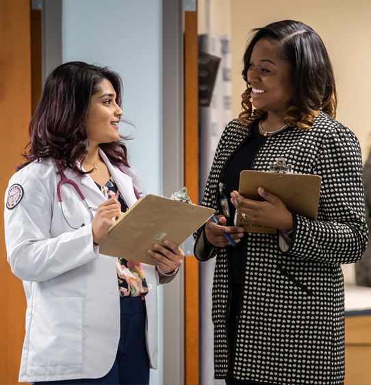 PCOM DO student and PsyD student discussing after seeing a patient