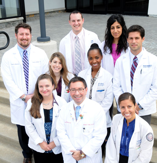 PCOM faculty, residents and students smile outside of the medical office building