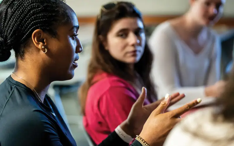 PCOM mental health counseling students actively engage in an evening group counseling session in which they explore real-world scenarios and apply what they learn.