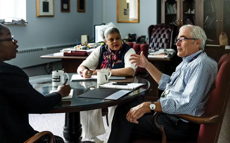 Office staff gather with Kenneth J. Veit, DO ’76, MBA, FACOFP, provost and senior vice president of academic affairs, PCOM. Through collaborative discussions and shared cups of coffee, they set the stage for a productive day ahead.