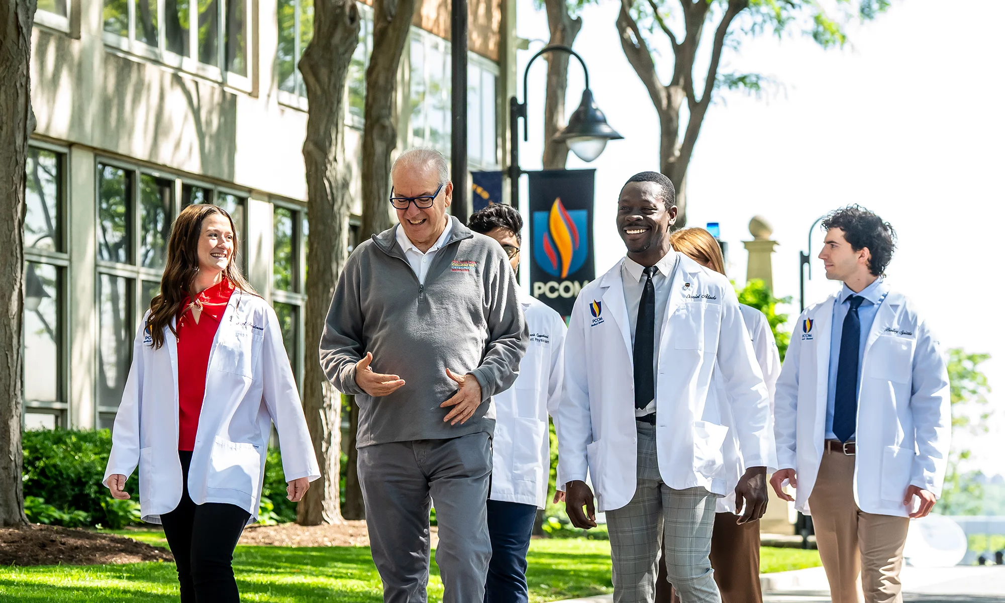 PCOM students walking with President Jay Feldstein, DO '81, on the Philadelphia campus