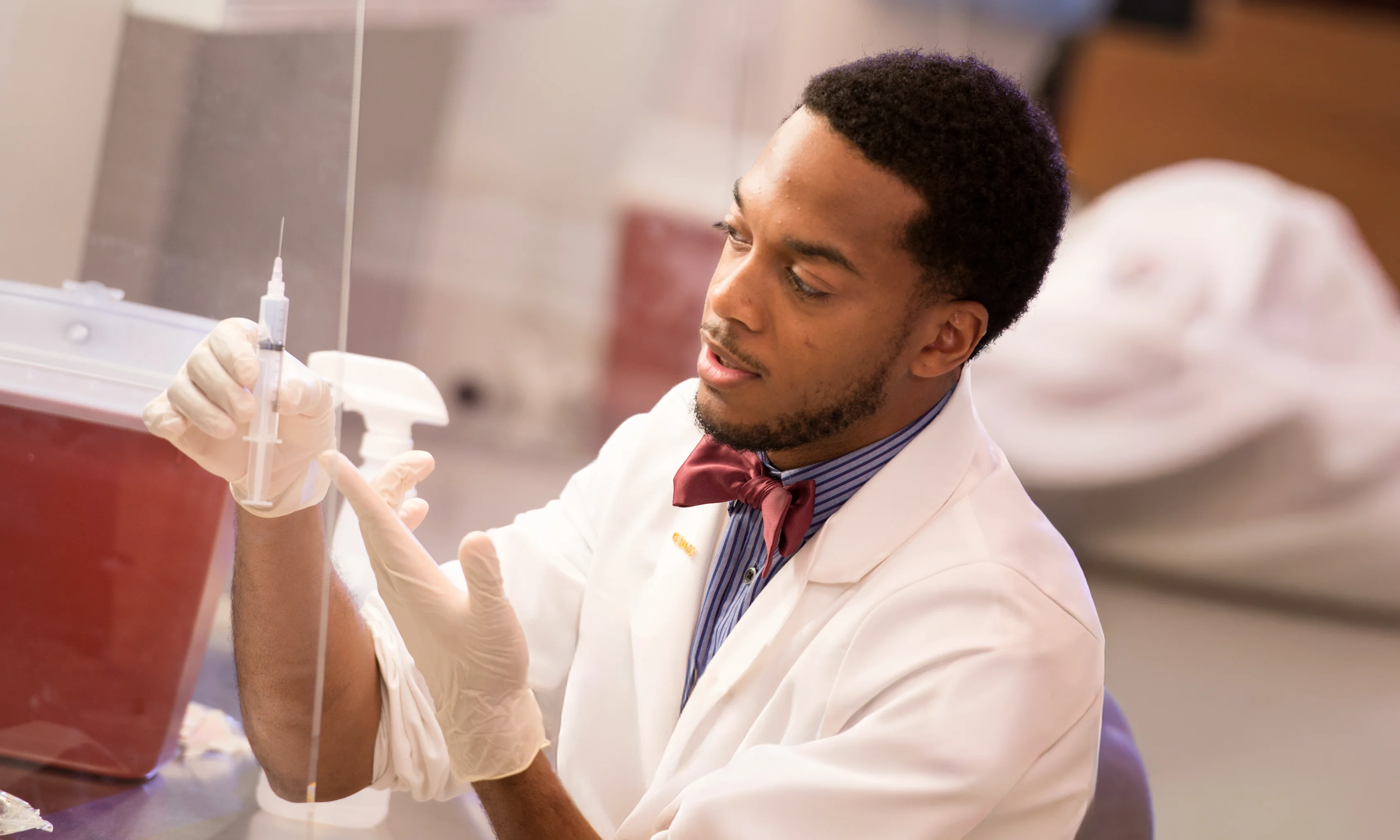 Pharmacy student conducting a hands-on learning exercise in a lab at PCOM Georgia