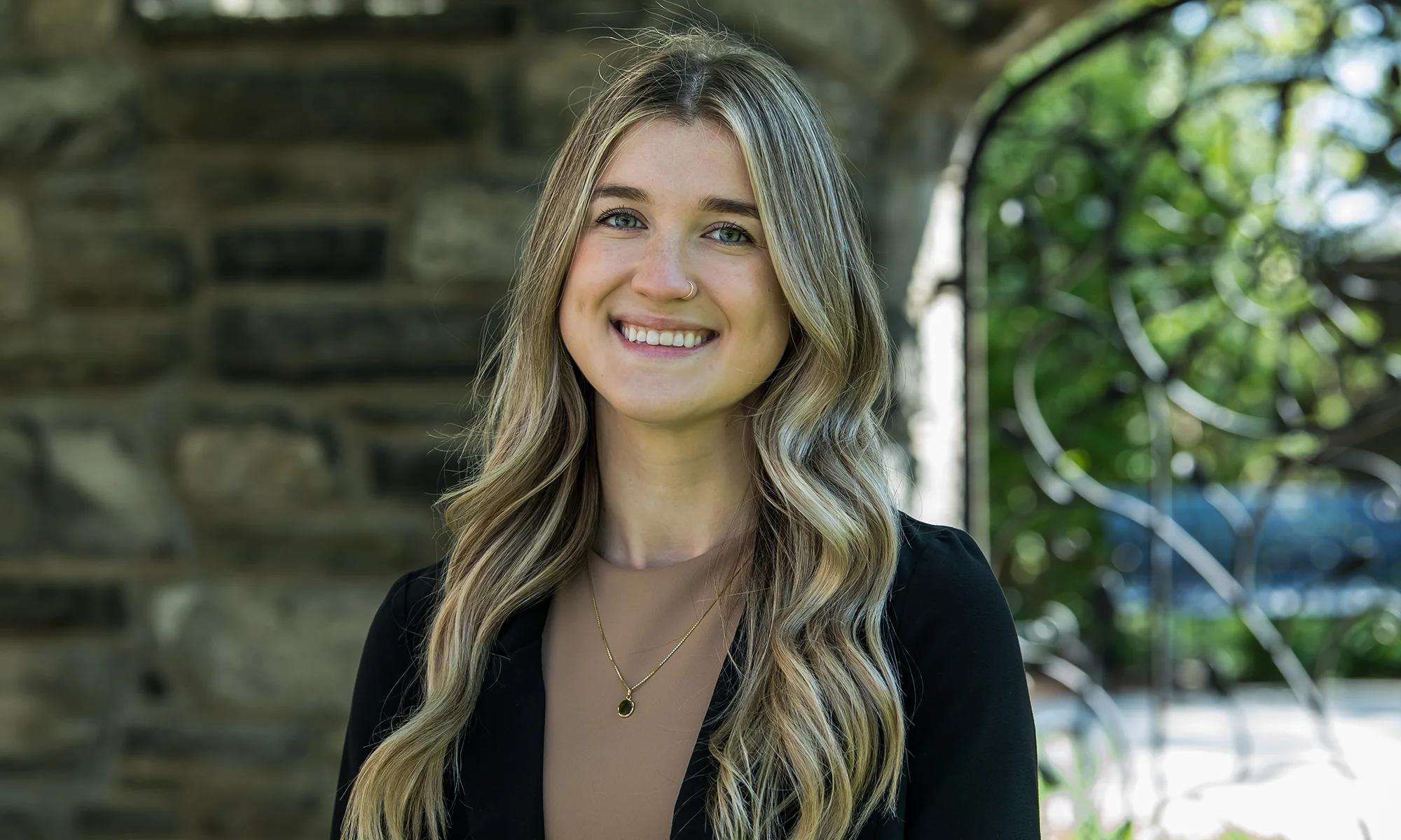 A PsyD in Clinical Psychology student smiles outside in professional attire outside at PCOM's Philadelphia campus