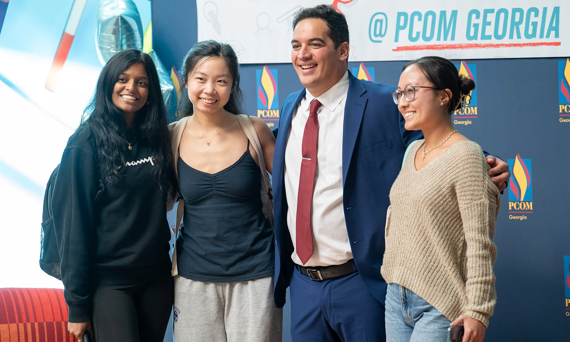 PCOM Georgia students smiling with a guest speaker during a campus event
