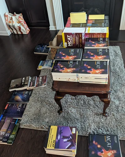 MCAT prep books stacked on a coffee table