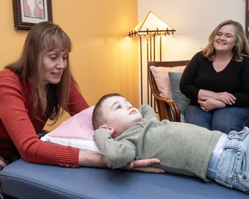 Dr. Victoria Troncoso practices osteopathic manipulative medicine on a young patient