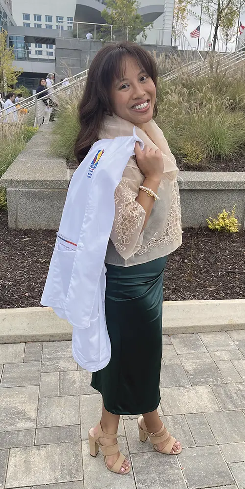 Photo of PCOM Georgia medical student Diane Janelle “DJ” Camonayan holding her student physician white coat.