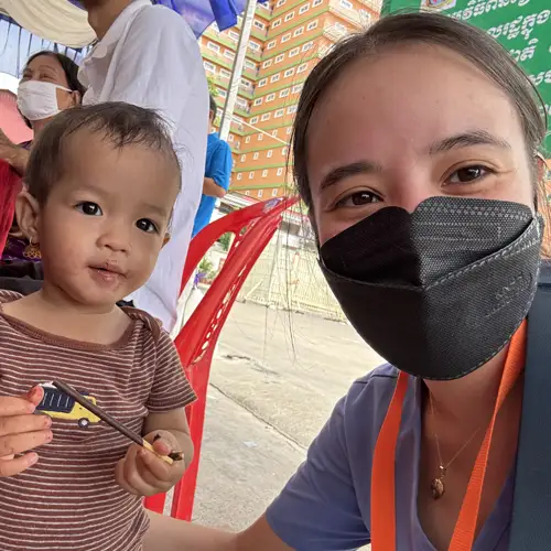 Brooke Demetri (DO '27) attends to a young child while on a relief trip in Cambodia