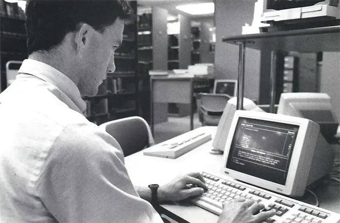 DO student at computer terminal in library