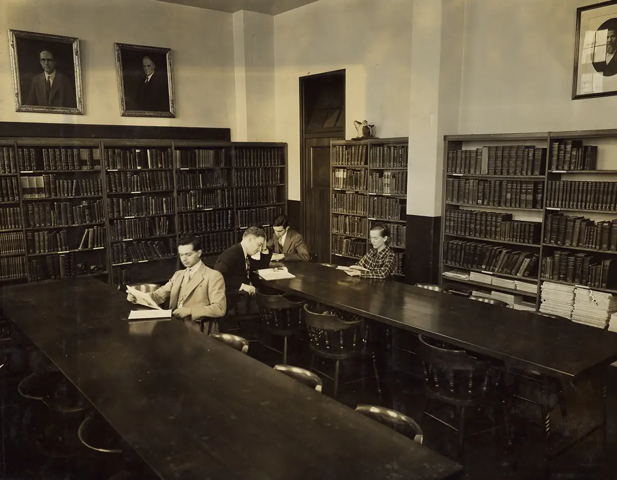 Old photograph of three students sitting in the PCOM Library