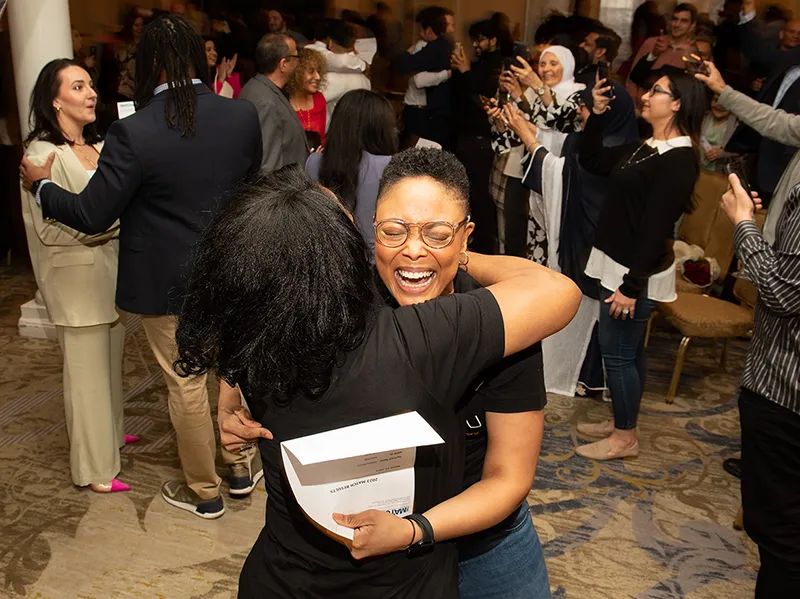 PCOM Georgia med students laugh and hug as they open their residency placement letters during a Match Day event