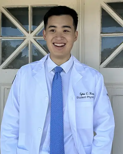 Photograph of PCOM med student Tyler Kung in white coat