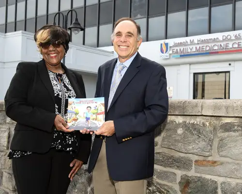 Arlene J. Surrency and Dr. Larry Finkelstein hold a copy of Surrency's children's book, Healthy Living Leads to a Healthy Me.