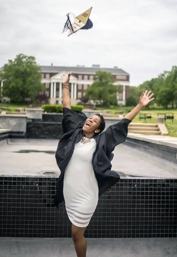 PCOM student Onorere “Ono” Okojie throws her cap in the air during her graduation from college