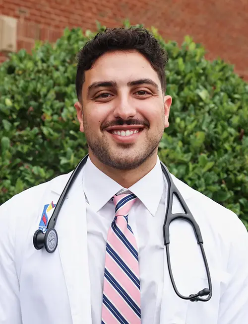 Headshot photo of PCOM South Georgia student Michael Abaskaron (DO '27) smiling and wearing his student physician white coat