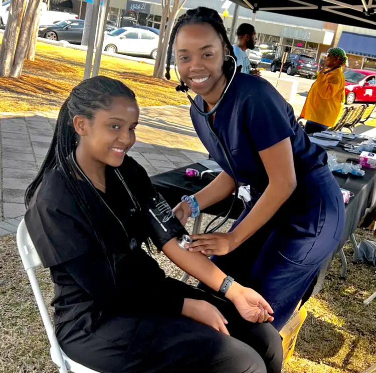 DO students take blood pressure readings at community event