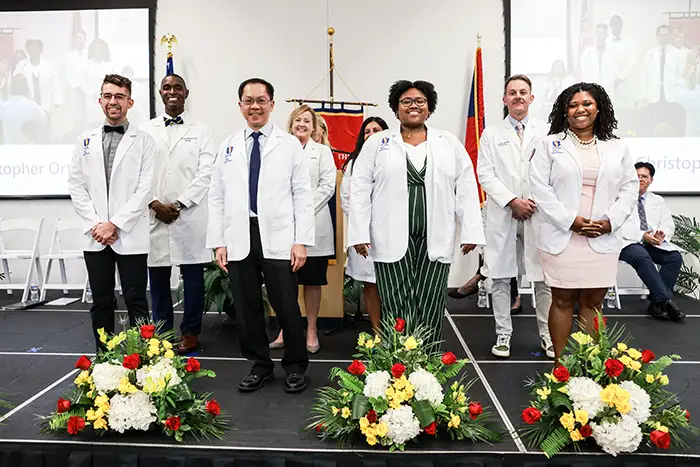 DO students are presented with their white coats on stage