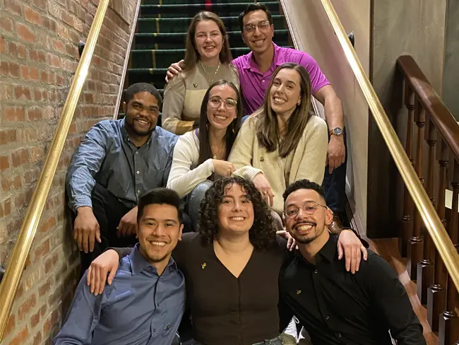 Students from PCOM's Clinical Scholars group smile in a group shot on a staircase