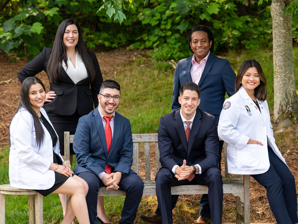 Students posing on a park bench