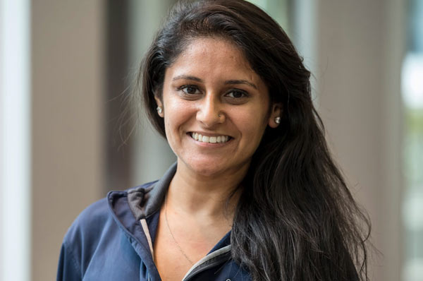 Closeup shot of smiling student with long, dark hair and a navy blue jacket