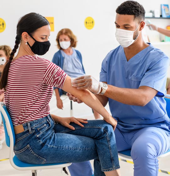 Physician assistant helping administer a vaccine to a patient at a health clinic