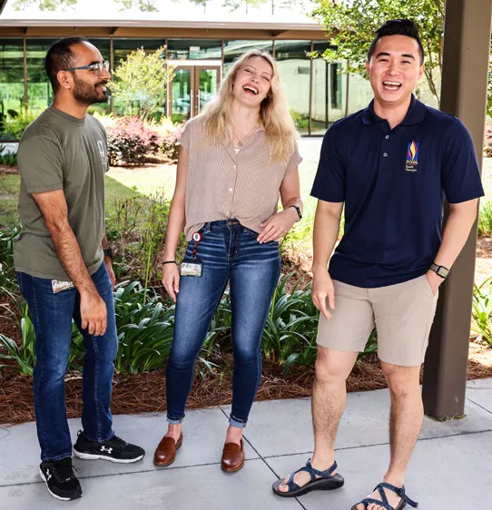 PCOM South Georgia grad students smiling and laughing in an outdoor couryard
