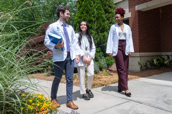 Three PCOM Georgia students walking together.