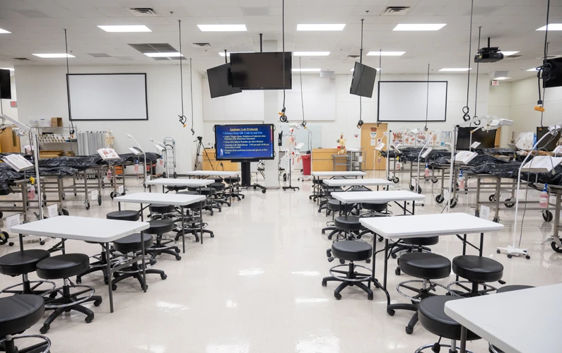 Large anatomy laboratory with chairs, tables and learning stations