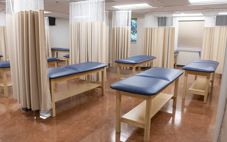 Exam tables and curtains in a large physician assistant studies learning suite at PCOM Georgia